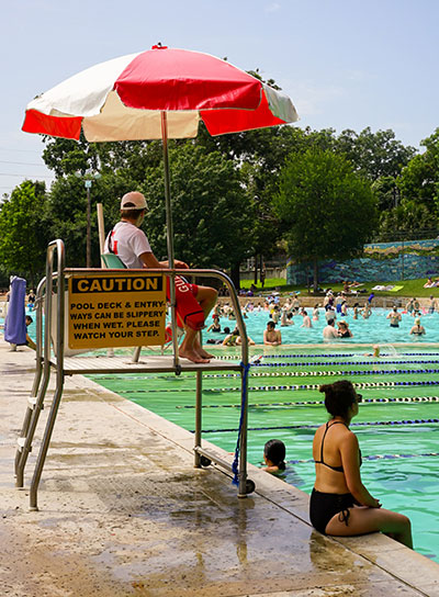 lifeguard sitting in stand overlooking commercial pool